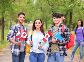 Image of multiple international students holding small Canada's flag in their hand