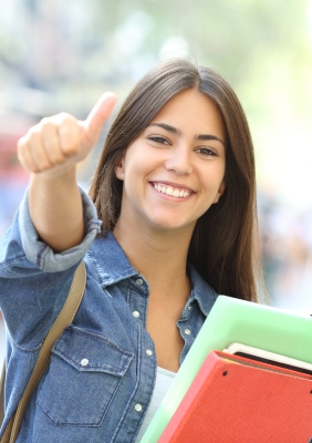 Portrait of an university student showing a thumbs up and smiling.