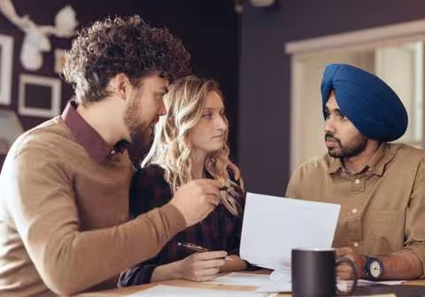 Immigration consultants explaining policies to a guy wearing a turban. Blog image
