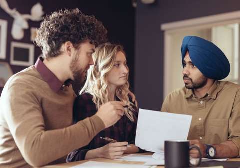 Immigration consultants explaining policies to a guy wearing a turban. Blog image